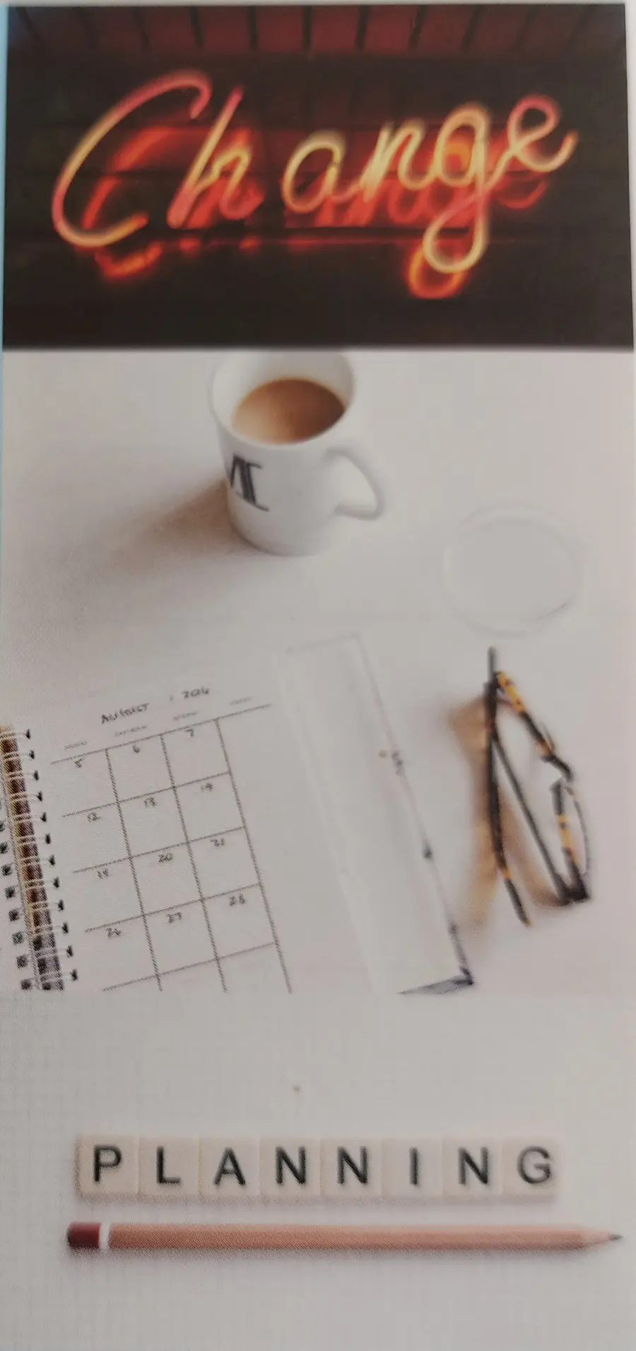 Eine Brille und ein Kalender liegen auf einer weißen Tischplatte, daneben eine Tasse Kaffee. Im Vordergrund das Wort Planning mit einem Bleistift und im Hintergrund das Wort Change.