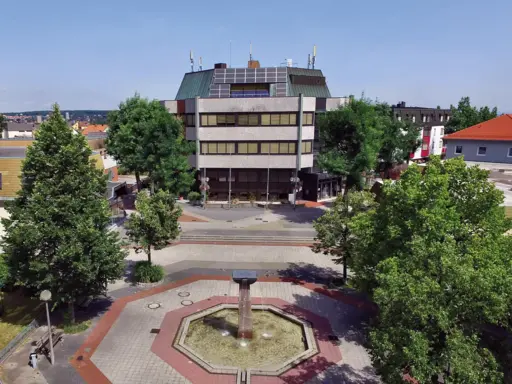 Luftaufnahme des Oberasbacher Rathauses von Süden. Rathausbrunnen im Vordergrund