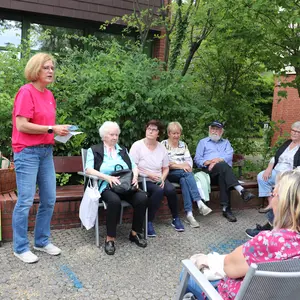 Teilnehmer eines Quiz zum Thema Hitzeschutz, links eine Infotafel zum UV-Index 