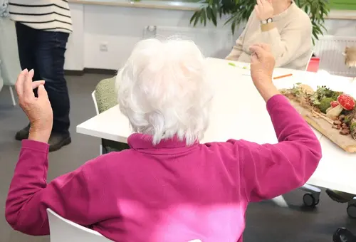 Alte Person, die die Hände erhoben hat, um eine Fingerübung zu machen. 