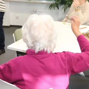 Alte Person, die die Hände erhoben hat, um eine Fingerübung zu machen. 