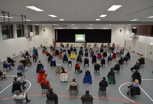 Das Bild zeigt die weitläufig bestuhlte Jahnhalle aus der hinteren Perspektive mit Blick Richtung Bühne