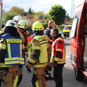 Verschiedene Helfer von Feuerwehr, THW und Kreisbrandinspektion stehen zusammen und besprechen sich.
