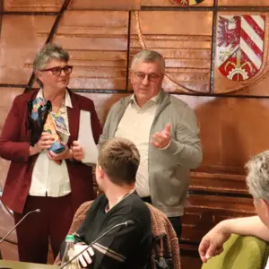 Sitzungssaal: Huber und Peter; andere Stadträte drehen sich um, um sie zu sehen.