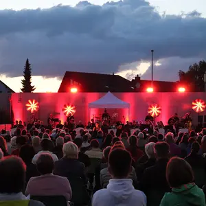 Blick auf die abgedunkelte Bühne mit wechselnden Lichteffekten (hier rot)