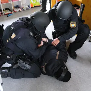 Polizeipersonen halten eine verdächtige Person auf dem Boden fest 