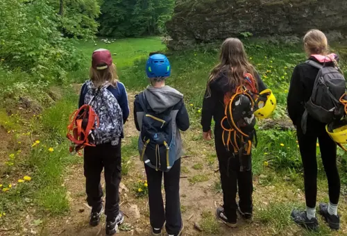 vier Kinder von hinten mit Klettermontur