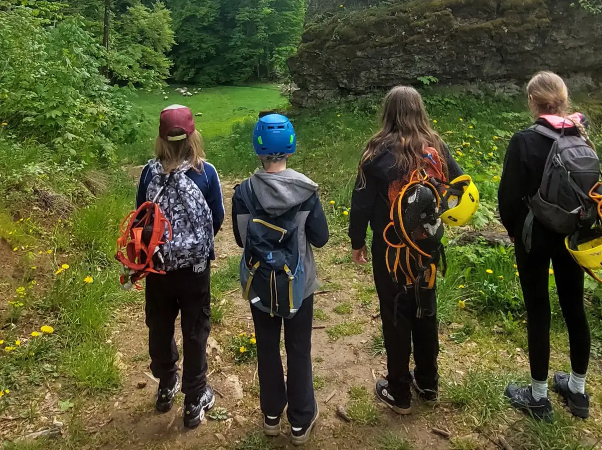 vier Kinder von hinten mit Klettermontur