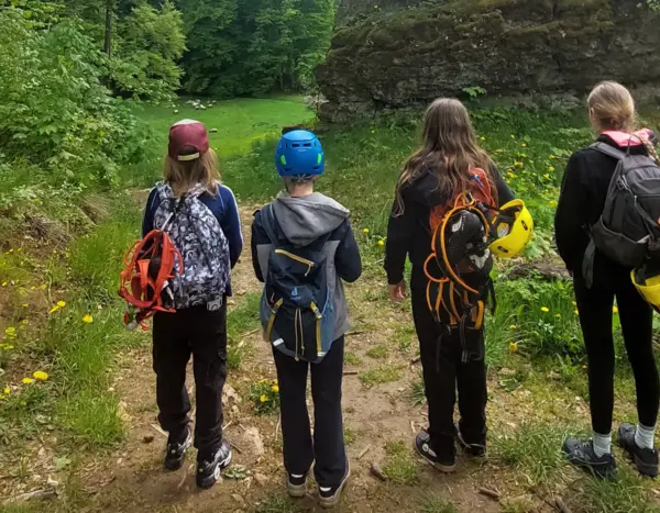 vier Kinder von hinten mit Klettermontur