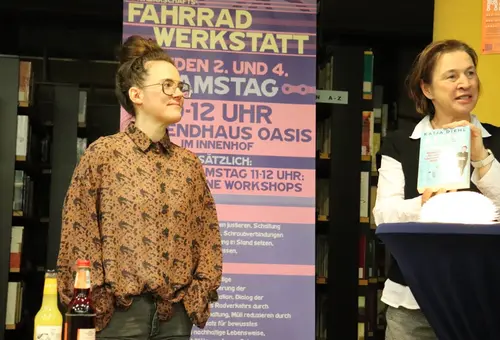 Katja Diehl links und Edith Backer rechts. Backer hält Diehls Buch "Autokorrektur" in der Hand. 