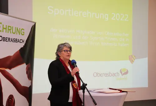 Birgit Huber vor Projektion Sportlerehrung 