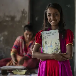 Junges dunkelhäutiges Mädchen mit Schulheft 