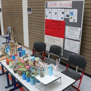 Tisch mit recycleten Alltagsutensilien wie Kerzen, Blumentöpfe etc.