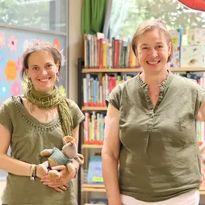 Zwei Frau in der Stadtbücherei blicken in die Kamera