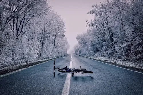 Fahrrad liegt auf Straße in Winterlandschaft