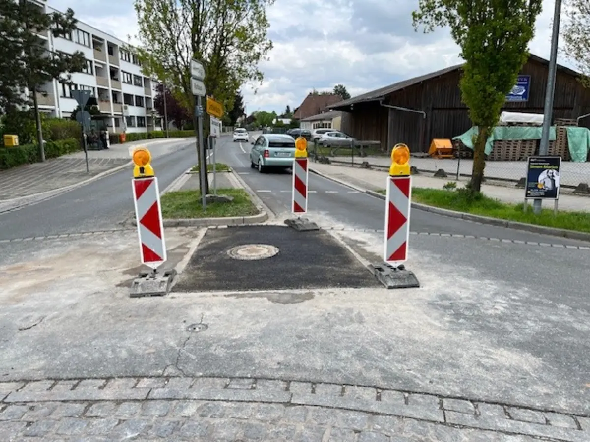 Ein Straße - ein Teil ist neu asphaltiert. Darum herum stehen drei Barken. 