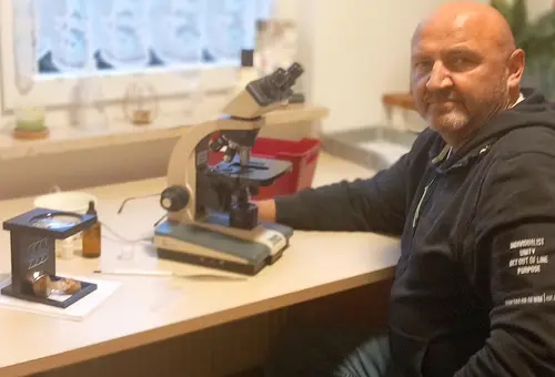 Mann sitzt for Mikroskop