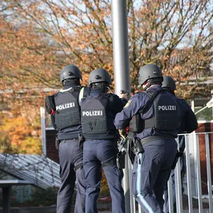 Polizeipersonen mit Helm und schusssicherer Weste von hinten