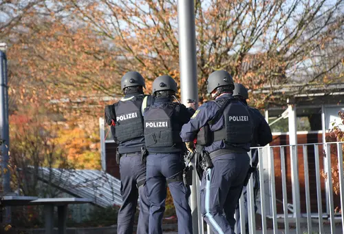 Polizeipersonen mit Helm und schusssicherer Weste von hinten