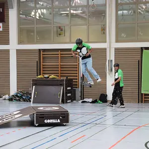 Scooterfahrer hoch in der Luft beim Sprung mit dem rotierenden Scooter.