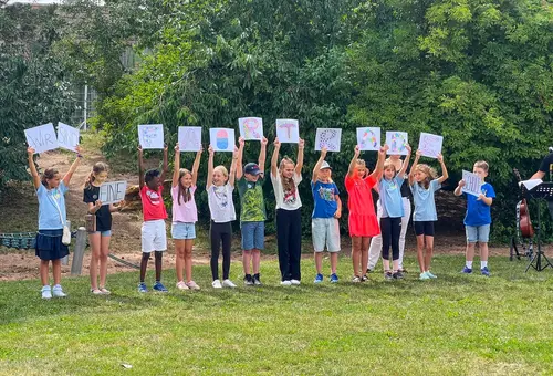 Elf Kinder stehen in einer Reihe und freuen sich über die Auszeichnung.