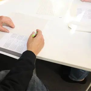 Tisch mit Händern und Blättern mit Knobelaufgaben 