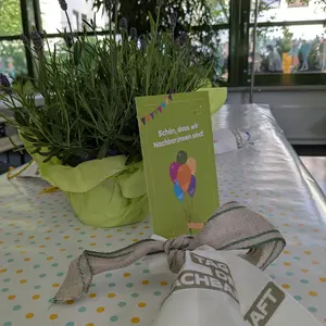 Lavendelstöckchen und Postkarte mit Aufschrift "Schön, dass wir Nachbar:innen sind"