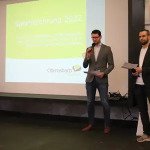 Gill und Gerstner vor Projektion Sportlerehrung 