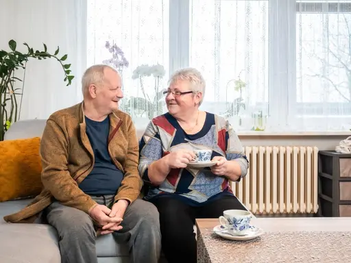 ein altes Ehepaar vor einer alten Heizung