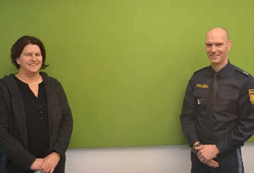 Eine Frau und ein Mann vor einer grünen Wand