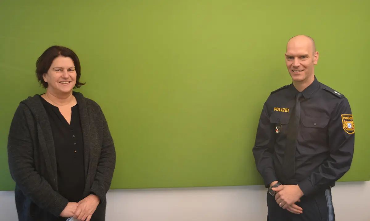 Eine Frau und ein Mann vor einer grünen Wand