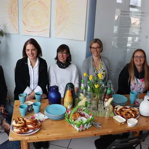 Sieben Frauen an einem Frühstückstisch