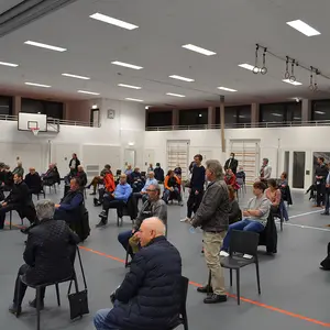 Die Mitglieder des Stadtrates haben sich von ihren Plätzen im Publikum erhoben.