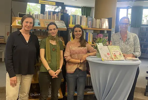 Vier Frauen um einen Stehtisch in der Stadtbücherei