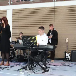 Jugendliche am Mikrofon, Keyboard, Schlagzeug und Bass