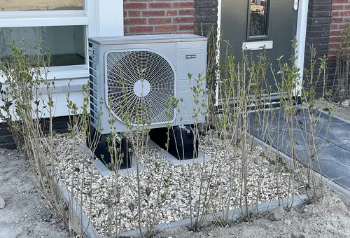 Eine vor einem Gebäude installierte Wärmepumpe 