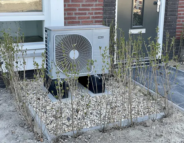 Eine vor einem Gebäude installierte Wärmepumpe 