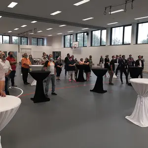 Gäste stehen an den Tischen unter Einhaltung der Abstandsregeln und mit Mundschutz.