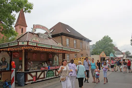 mehrere Buden stehen auf der Straße, dahinter Gemeindehaus und Kirche St. Lorenz