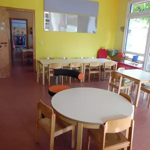 Kindergarten RegenbogenInnenbereich mit Tischen und Stühlen