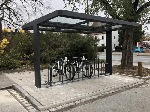 Überdachter Fahrradständer mit zwei Rädern. 