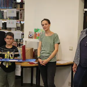 Ein Kind zeigt seine selbstgebaute Brücke.