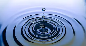 Wassertropfen springt aus Wasseroberfläche hoch