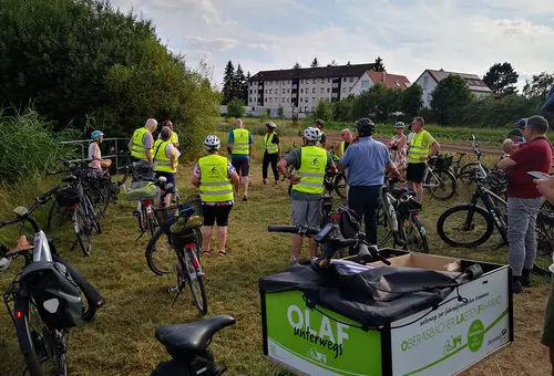 Eine Gruppe Radler in der grünen Wiese am Rande des RRB