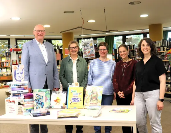 Ein Mann und vier Frauen hinter einem Tisch mit Büchern
