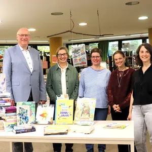 Ein Mann und vier Frauen hinter einem Tisch mit Büchern