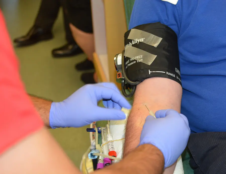 Die Nadel wird in die Armvene eines Mannes zur Blutspende eingeführt.