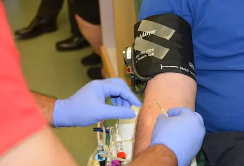 Die Nadel wird in die Armvene eines Mannes zur Blutspende eingeführt.