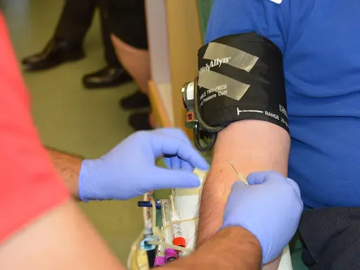 Die Nadel wird in die Armvene eines Mannes zur Blutspende eingeführt.