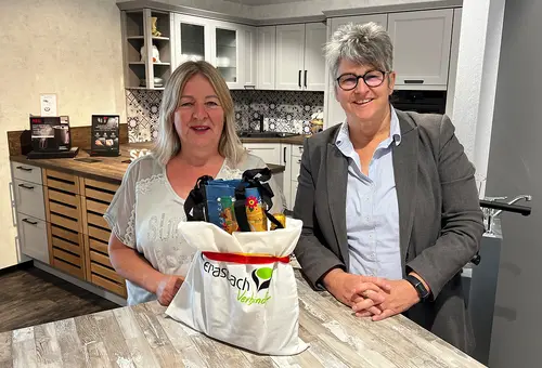 Zwei Frauen in einem Küchenstudio mit einem Geschenk auf einem Tisch